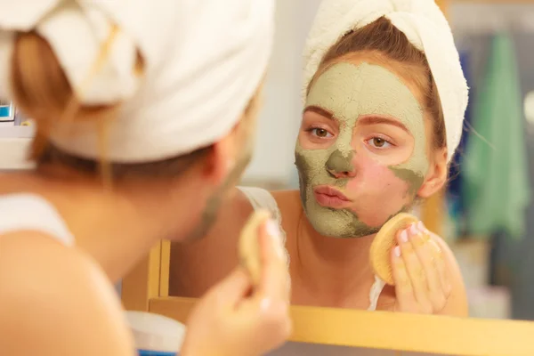 Vrouw verwijderen masker in badkamer — Stockfoto