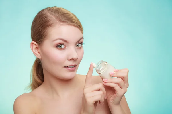 Mujer aplicando crema en su cara de piel. — Foto de Stock