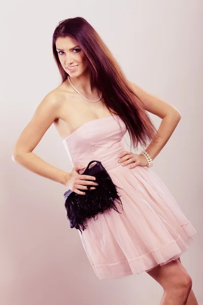 Brunette woman in bright dress with clutch bag — Stock Photo, Image