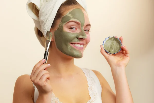 Femme appliquant avec un masque de boue d'argile brosse sur son visage — Photo