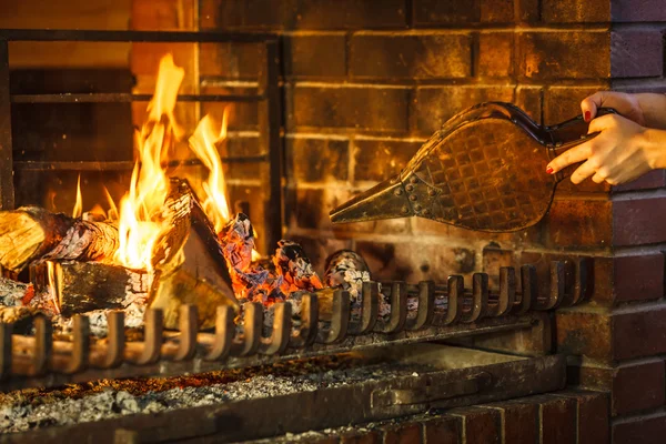 Primer plano manos chimenea haciendo fuego con fuelle . — Foto de Stock