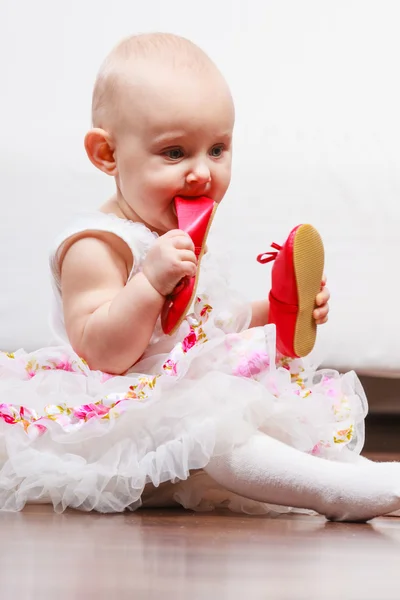 Baby girl biting shoe — Stock Photo, Image