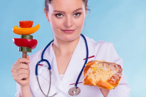 Dietitian with sweet roll bun and vegetables. — Stock Photo, Image