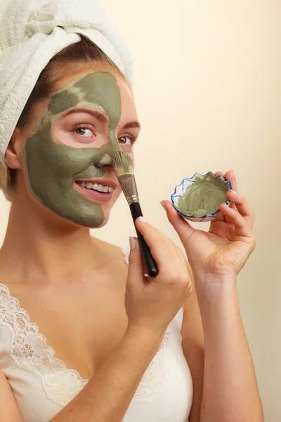 Femme appliquant avec un masque de boue d'argile brosse sur son visage — Photo