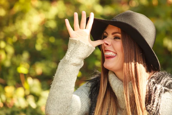 Chica en sombrero negro con el dedo pulgar a la nariz gesto —  Fotos de Stock