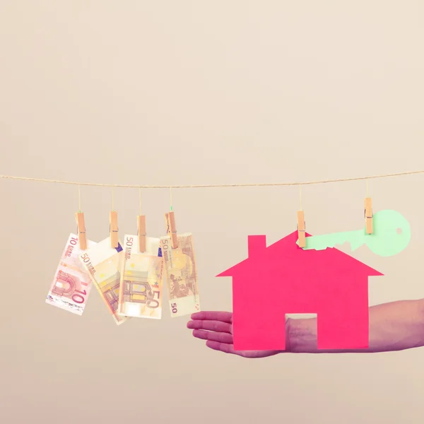 Male hand showing house and money — Stock Photo, Image