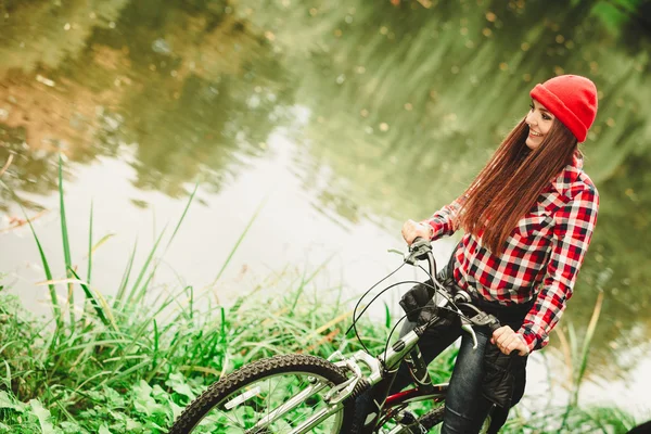 Girl relaxing in autumnal park with bicycle. — Stock Photo, Image