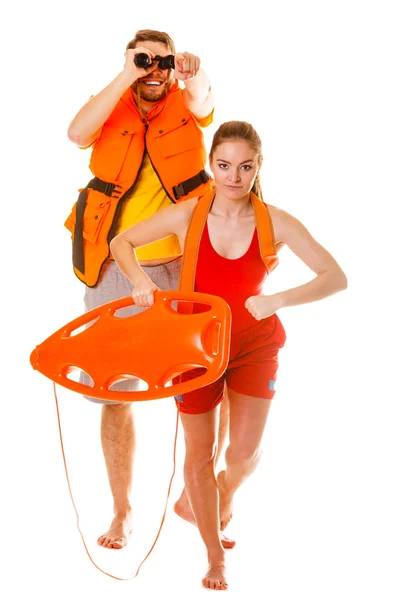 Lifeguards in life vest with rescue buoy running — Stock Photo, Image