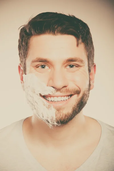 Hombre feliz con espuma crema de afeitar en la mitad de la cara . —  Fotos de Stock