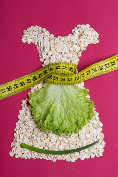 Dress shape made from oatmeal with measuring tape — Stock Photo, Image