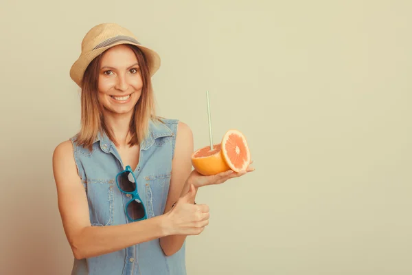Женщина в шляпе с солнцезащитными очками и грейпфрутом — стоковое фото