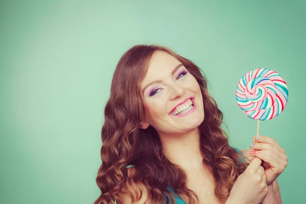 Menina sorridente com doces pirulito em teal — Fotografia de Stock