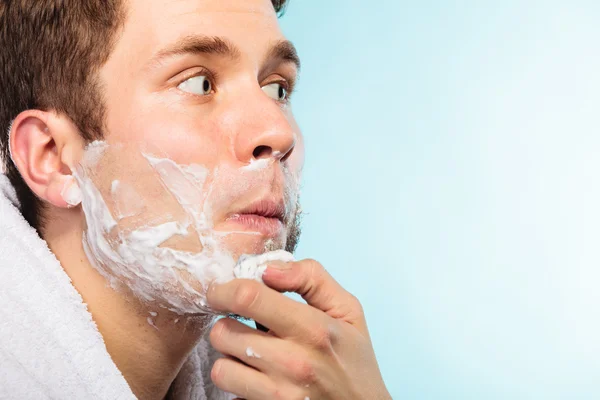 Young man shaving using razor with cream foam. — Stock Photo, Image