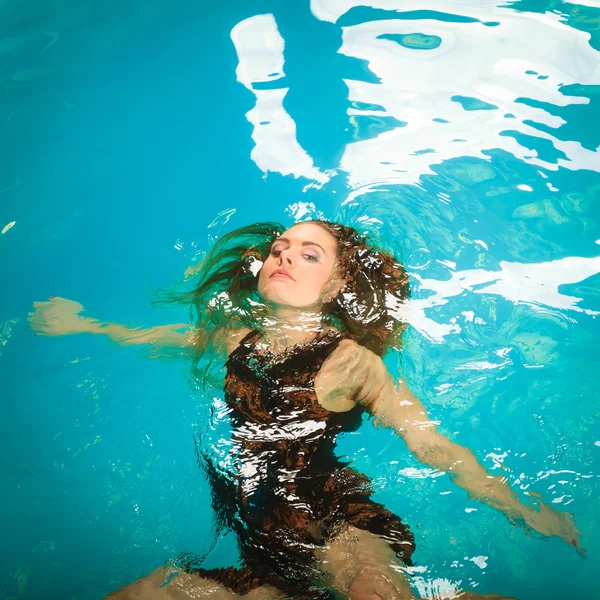 Frau schwimmt entspannt im Schwimmbadwasser. — Stockfoto