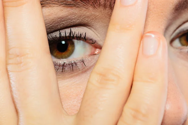 Mujer cubrir la cara mirada a través de los dedos . — Foto de Stock