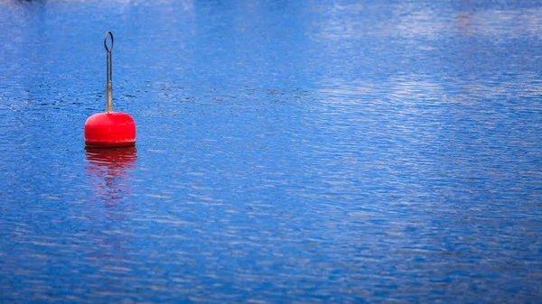 Single red buoy on calm blue sea surface — Stock Photo, Image