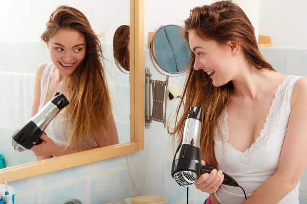 Mulher de cabelos longos secando o cabelo no banheiro — Fotografia de Stock