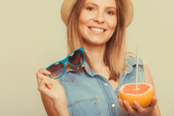 Lycklig kvinna i hatt innehar solglasögon och grapefrukt — Stockfoto