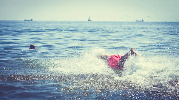 Un hombre corriendo salpicando el agua del mar. Diversión — Foto de Stock