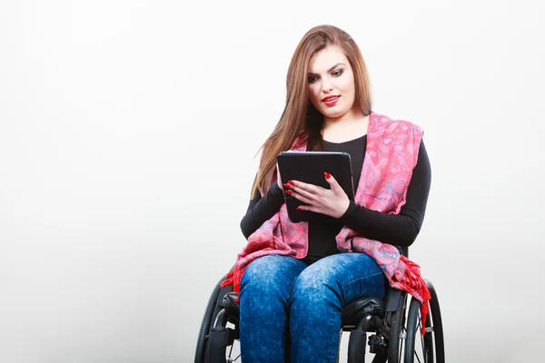 Behinderte Frau im Rollstuhl mit Tablet - Stockfotografie