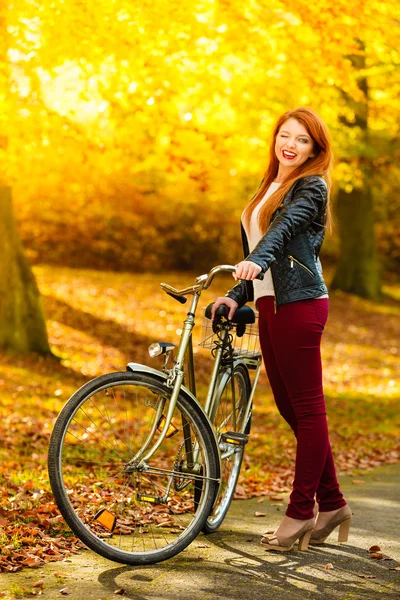 Chica de belleza relajante en el parque de otoño con bicicleta, al aire libre — Foto de Stock