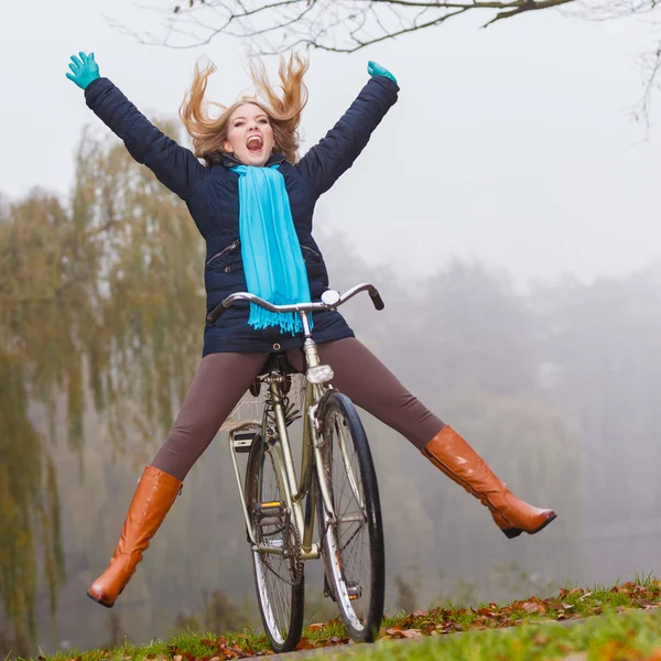 Mujer activa que se divierte montando bicicleta en el parque de otoño —  Fotos de Stock