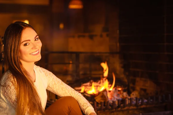 Mujer feliz relajándose en la chimenea. Casa de invierno . —  Fotos de Stock