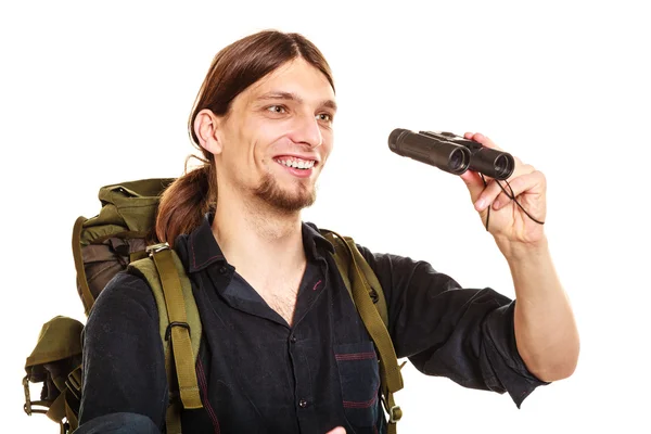 Man tourist backpacker looking through binoculars. — Stock Photo, Image