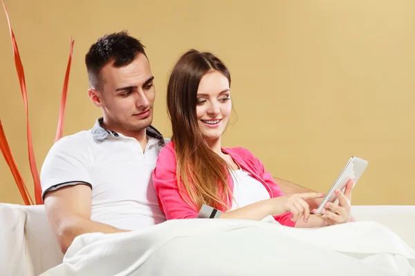 Young couple with tablet and credit card at home — Stock Photo, Image
