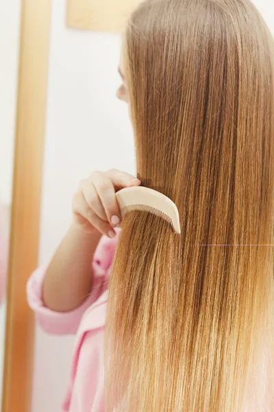Γυναίκα χτενίζει τα μαλλιά της μακρύ ομαλό — Φωτογραφία Αρχείου