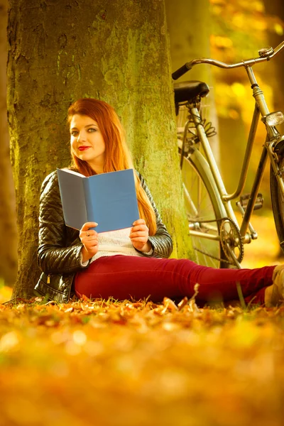 Hermosa chica está leyendo bajo el árbol . —  Fotos de Stock