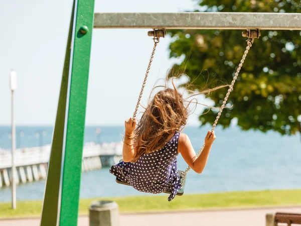 Girl swinging on swing-set. — Stock Photo, Image