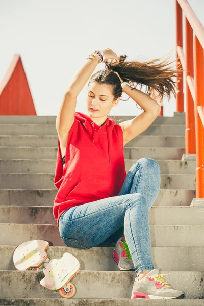 Chica con monopatín sentado —  Fotos de Stock