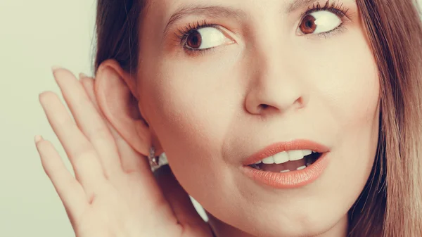 Girl eavesdropping with hand to ear. — Stock Photo, Image