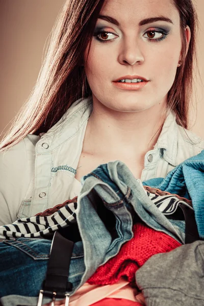 Menina segurando pilha de roupas coloridas . — Fotografia de Stock