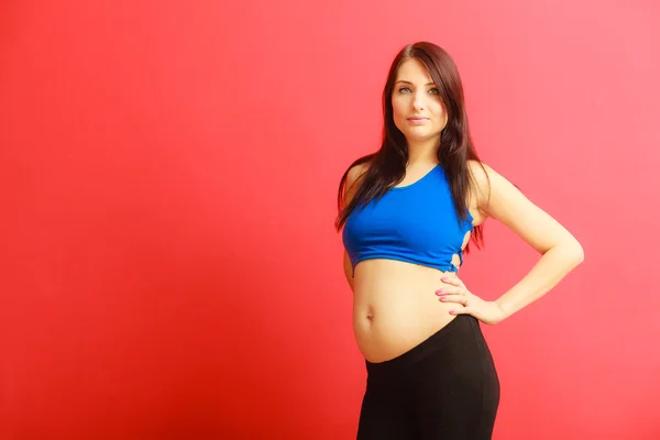 Cabello largo en forma de mujer embarazada en rojo — Foto de Stock