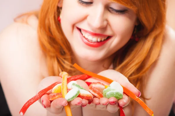 Redhair girl holding sweet food jelly candy on pink. — Stock Photo, Image