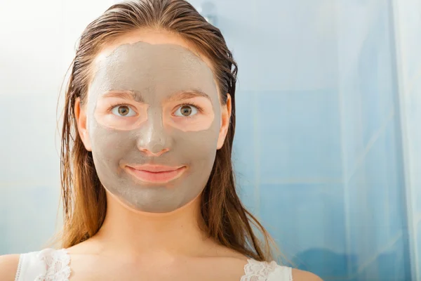 Rosto de mulher com máscara de barro facial — Fotografia de Stock
