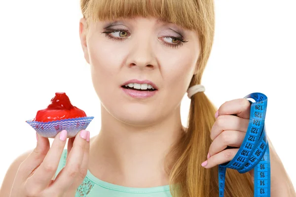 Woman holds cupcake trying to resist temptation — Stock Photo, Image