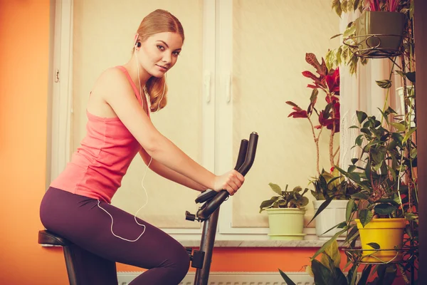 Mujer haciendo ejercicio en bicicleta estática . — Foto de Stock