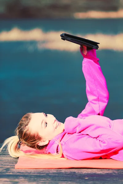 Menina deitada no parque usando tablet . — Fotografia de Stock