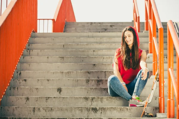Mädchen mit Skateboard sitzend — Stockfoto