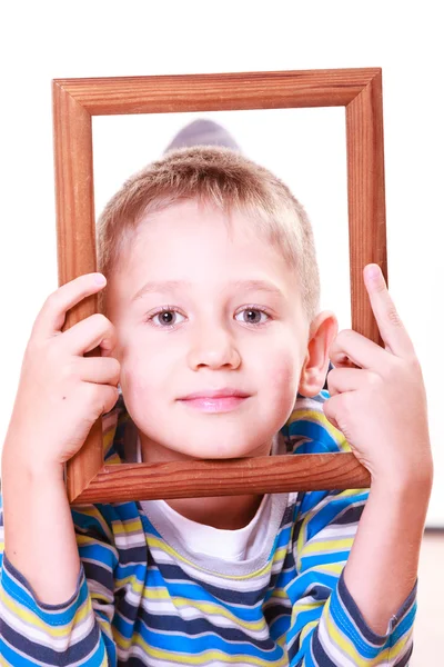 Kleiner Junge spielt mit leerem Rahmen. — Stockfoto