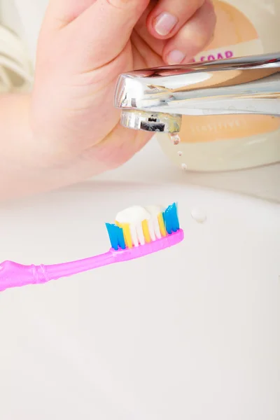 Dentifrice sur brosse à dents à la main femme — Photo