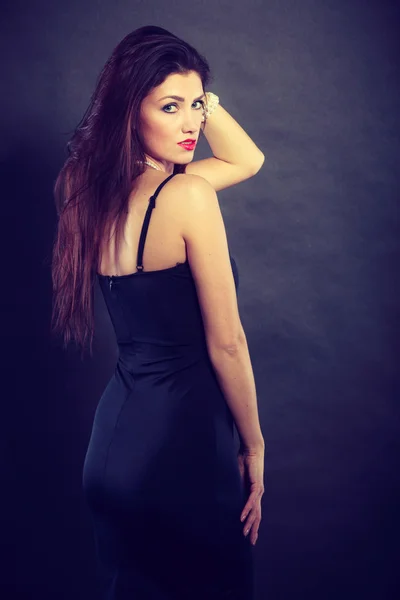 Vrouw in sensuele zwarte jurk op donker — Stockfoto