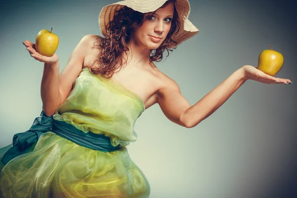 Woman in dress and hat hold yellow apple — Stock Photo, Image