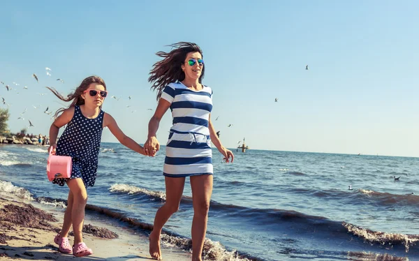 Feliz familia despreocupada corriendo en la playa en el mar . — Foto de Stock