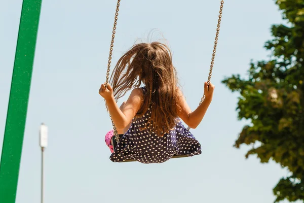 Girl swinging on swing-set. — Stock Photo, Image