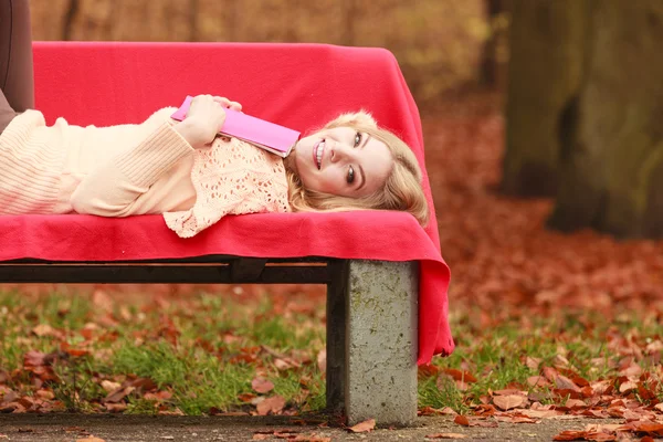 本を秋の公園でリラックスできる女性. — ストック写真