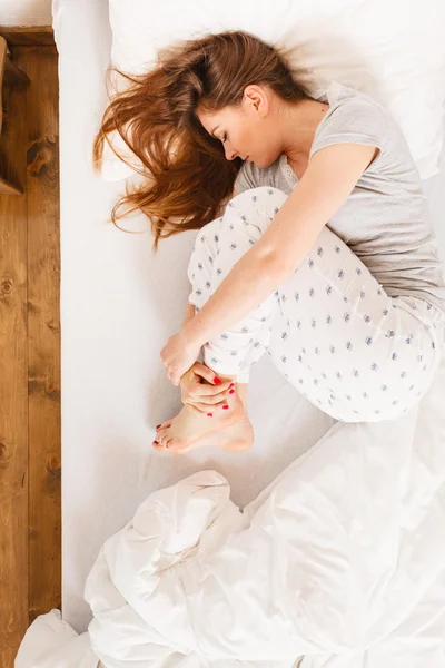 Sömnig kvinna sover i sängen. — Stockfoto